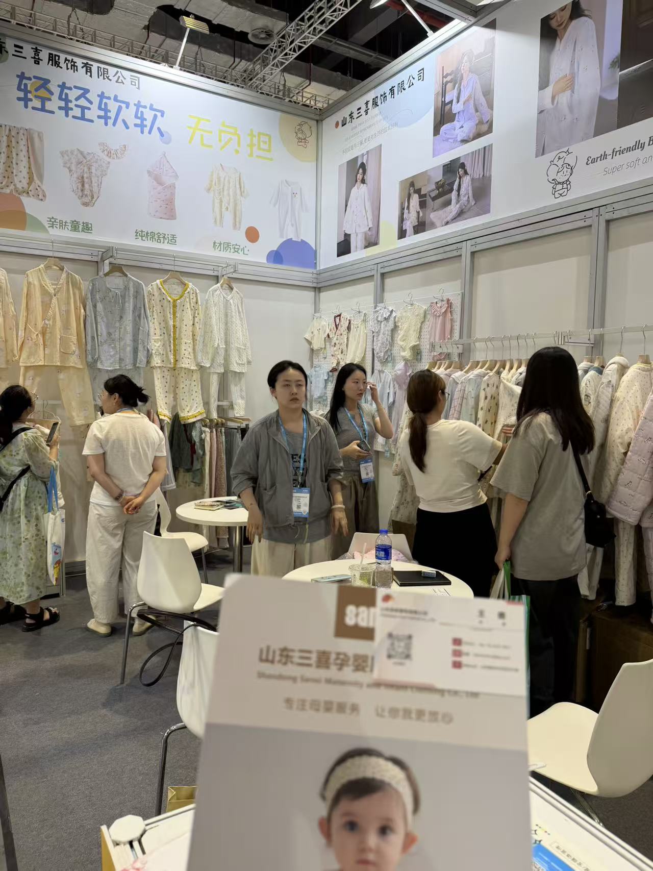Baby clothing and feeding bib products displayed at a CBME supplier booth
